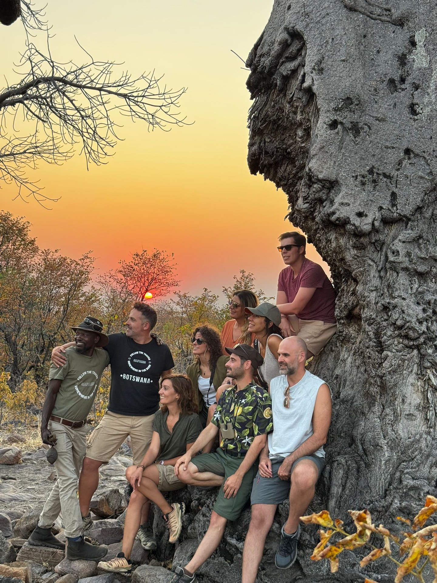 Grupo de viajeros al atardecer junto a un baobab en Botswana